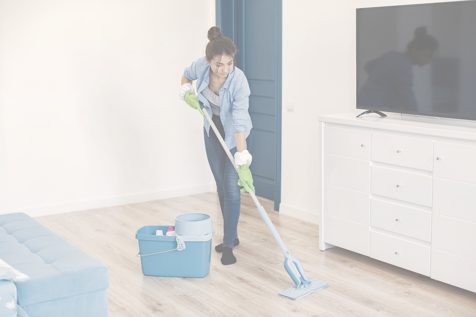 Woman with mop and rubber gloves cleaning house